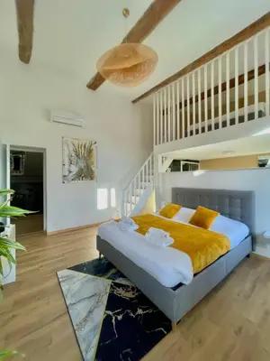 a bedroom with a bed with a yellow blanket at Les 3 anges de Sigean maison bourgeoise chambre d hôtes table d hôtes et Spa in Sigean