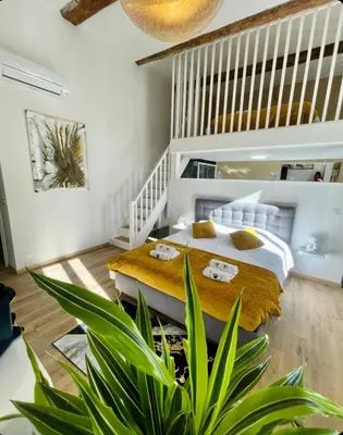 a bedroom with a bed and a staircase at Les 3 anges de Sigean maison bourgeoise chambre d hôtes table d hôtes et Spa in Sigean