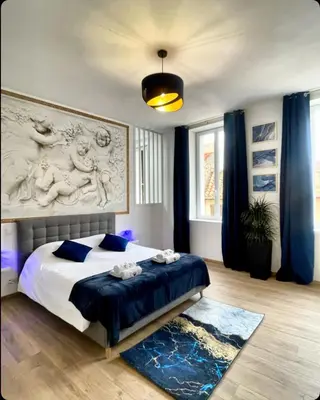 a bedroom with a king sized bed with blue curtains at Les 3 anges de Sigean maison bourgeoise chambre d hôtes table d hôtes et Spa in Sigean