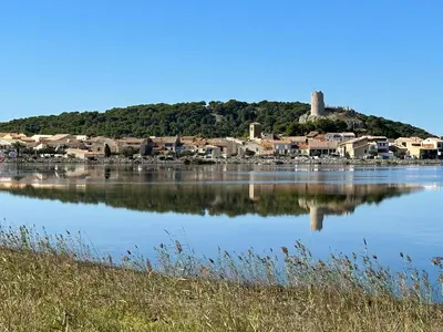 a large body of water with a town on a hill at Appartement spacieux de plein pied avec 2 chambres, cuisine, salon, terrasse à 2 minutes de la plage in Gruissan