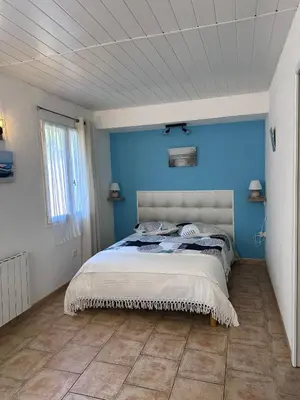 a bedroom with a blue wall and a bed at Appartement spacieux de plein pied avec 2 chambres, cuisine, salon, terrasse à 2 minutes de la plage in Gruissan