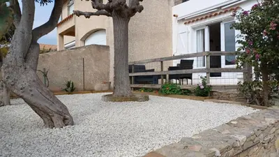 a tree sitting in the middle of a yard at Appartement spacieux de plein pied avec 2 chambres, cuisine, salon, terrasse à 2 minutes de la plage in Gruissan