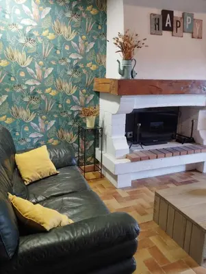 a living room with a couch and a fireplace at Amé-lys in Véraza
