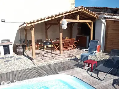 a patio with a table and chairs and a grill at Amé-lys in Véraza
