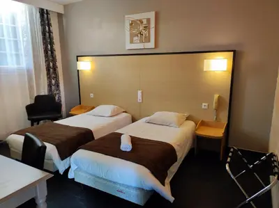 a hotel room with two beds and a large headboard at Hôtel et Appart'Hôtel Le Relais Du Val D'Orbieu in Ornaisons