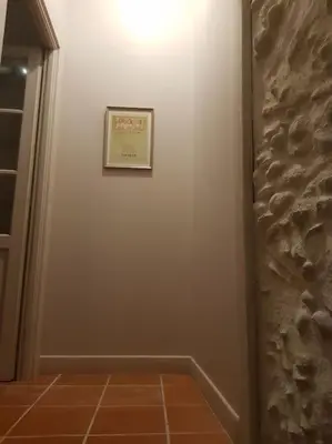 a hallway with a picture on a white wall at Le gîte Joyeuse triplette Limoux Carcassonne in Limoux