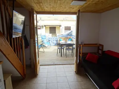 a room with a door open to a patio with a table and chairs at Maison près des plages in Port-la-Nouvelle