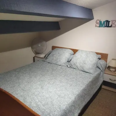 a bed with two pillows on it in a bedroom at Maison près des plages in Port-la-Nouvelle