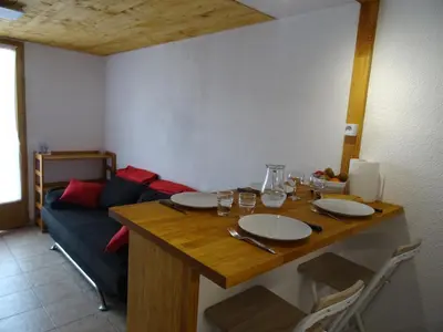 a table in a living room with a blue couch at Maison près des plages in Port-la-Nouvelle