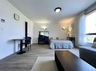 a bedroom with a bed and a table and a couch at Zen studio ※ parking - piscine in Carcassonne