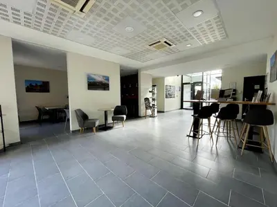 an empty room with chairs and tables in a building at Zen studio ※ parking - piscine in Carcassonne