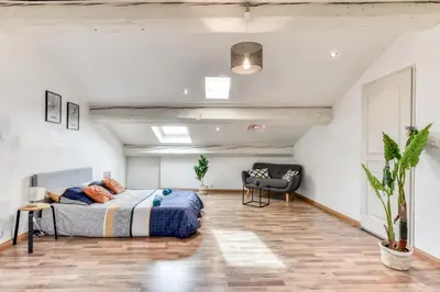 a bedroom with a bed and a chair in it at El Marty - central - climatisation - parking gratuit - wifi in Carcassonne