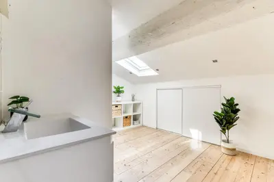 a kitchen with white walls and a wooden floor at El Marty - central - climatisation - parking gratuit - wifi in Carcassonne