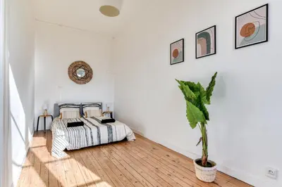 a bedroom with a bed and a potted plant at El Marty - central - climatisation - parking gratuit - wifi in Carcassonne