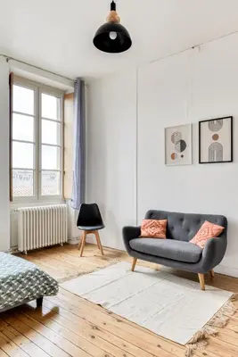 a living room with a couch and a chair at El Marty - central - climatisation - parking gratuit - wifi in Carcassonne