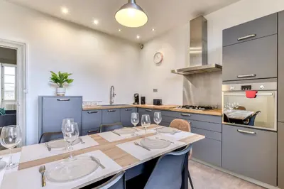 a kitchen with a table with wine glasses on it at El Marty - central - climatisation - parking gratuit - wifi in Carcassonne