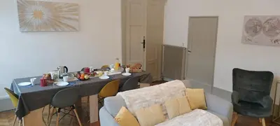 a living room with a table and a couch at Grand Appartement Hyper Centre Castres 5 Chambres 10 personnes in Castres