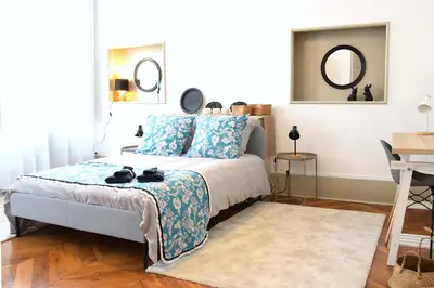 a bedroom with a bed with blue pillows and a mirror at Grand Appartement Hyper Centre Castres 5 Chambres 10 personnes in Castres