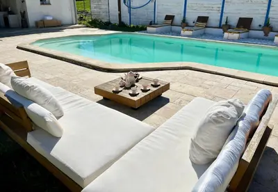 a swimming pool with two chaise lounges and a table and a pool at Villa les cigales - Paisible avec piscine in Mas-Saintes-Puelles