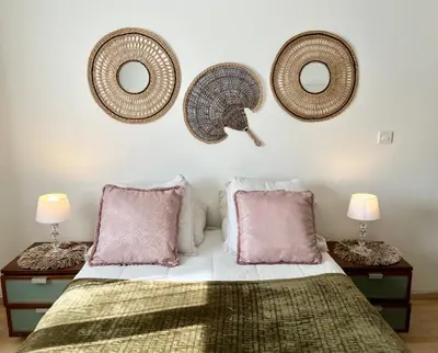 a bedroom with a bed with two tables and two mirrors at Villa les cigales - Paisible avec piscine in Mas-Saintes-Puelles