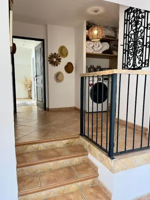 a hallway with a staircase with a wrought iron gate at Villa les cigales - Paisible avec piscine in Mas-Saintes-Puelles