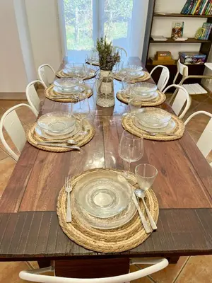 a wooden table with plates and silverware on it at Villa les cigales - Paisible avec piscine in Mas-Saintes-Puelles