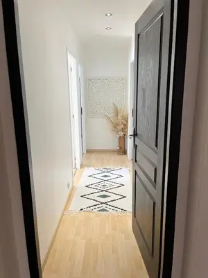 a hallway with an open door and a rug at Villa les cigales - Paisible avec piscine in Mas-Saintes-Puelles