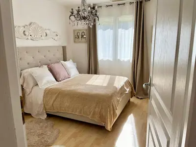 a bedroom with a bed and a chandelier at Villa les cigales - Paisible avec piscine in Mas-Saintes-Puelles