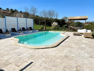 a swimming pool in a yard with a patio at Villa les cigales - Paisible avec piscine in Mas-Saintes-Puelles