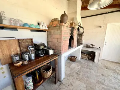 a kitchen with a brick oven in a room at Villa les cigales - Paisible avec piscine in Mas-Saintes-Puelles