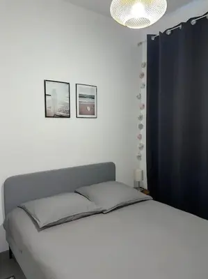 a bedroom with a bed and two pictures on the wall at Appartement central à Castelnaudary in Castelnaudary