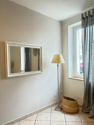 a room with a mirror and a lamp and a window at Appartement central à Castelnaudary in Castelnaudary