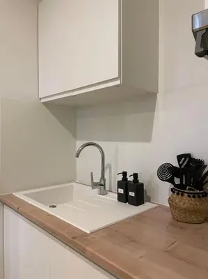 a white kitchen counter with a sink and a faucet at Appartement central à Castelnaudary in Castelnaudary