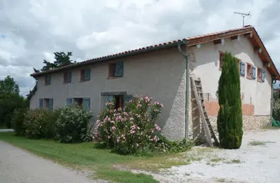 a small house with flowers in front of it at B&B La Ferme de Loubens in Loubens-Lauragais