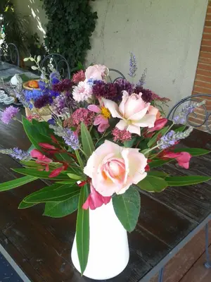 a white vase filled with flowers on a table at B&B La Ferme de Loubens in Loubens-Lauragais