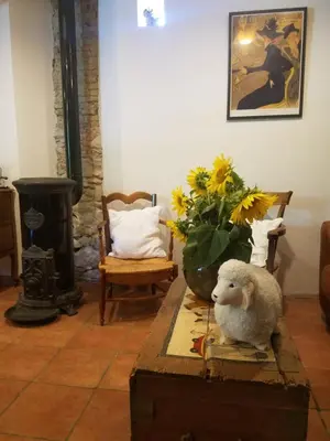 a stuffed lamb sitting on top of a wooden table in a living room at B&B La Ferme de Loubens in Loubens-Lauragais