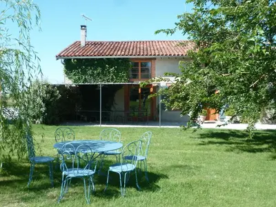 a table and chairs in the yard of a house at B&B La Ferme de Loubens in Loubens-Lauragais