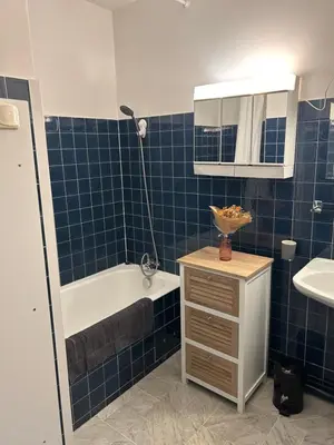 a blue tiled bathroom with a tub and a sink at Le studio de Simon au pied de la cité in Carcassonne