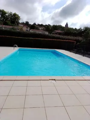 a swimming pool with blue water in a yard at Agréable pavillon in Nailloux