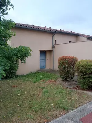 a house with a blue door and a yard at Agréable pavillon in Nailloux