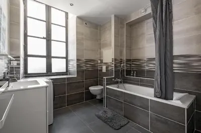 a bathroom with a tub and a toilet and a sink at Centre Ville -Cosy 2 pièces-Clim-AF in Carcassonne