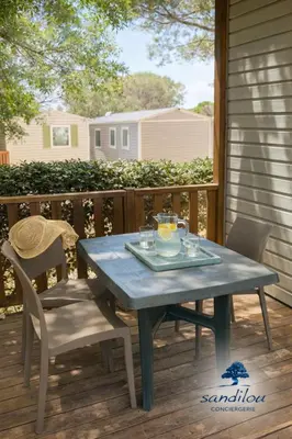 a blue table and chairs on a porch with a table at MOBILHOME OLIVIER - Camping avec piscine à Port-la-Nouvelle in Port-la-Nouvelle