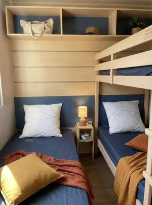 a bedroom with two bunk beds and a lamp at MOBILHOME OLIVIER - Camping avec piscine à Port-la-Nouvelle in Port-la-Nouvelle