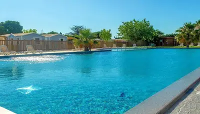 a large pool with blue water in a yard at MOBILHOME OLIVIER - Camping avec piscine à Port-la-Nouvelle in Port-la-Nouvelle
