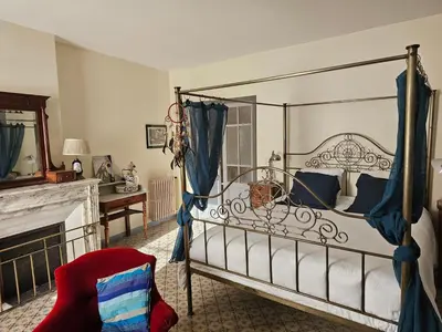 a bedroom with a canopy bed and a fireplace at L Aparté en Corbières in Ferrals-lès-Corbières