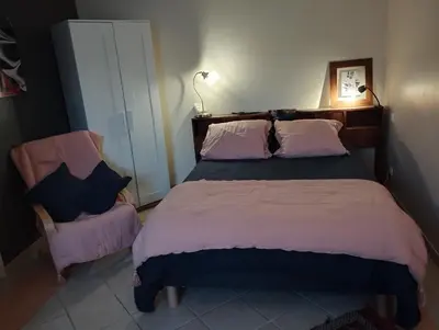 a bedroom with a large bed and a chair at L Aparté en Corbières in Ferrals-lès-Corbières