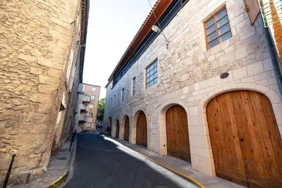 an alley with brown wooden doors on a building at Petit studio presbytère dans L'Église in Narbonne