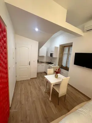 a room with a dining table and a kitchen at Petit studio presbytère dans L'Église in Narbonne