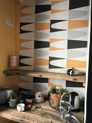a kitchen counter with a sink and a striped wall at BelCiano (ancien Toit Vert) in Fitou