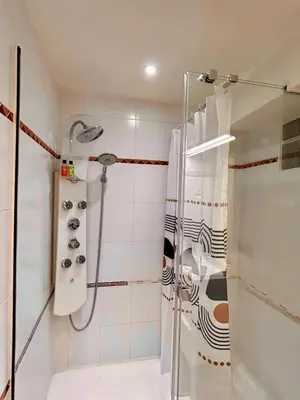 a bathroom with a shower with a shower curtain at Le Victor Hugo de la Robine in Narbonne